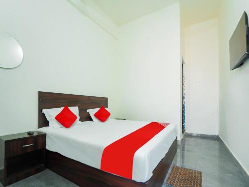 una camera da letto con un grande letto con cuscini rossi di SPOT ON Hotel Friend's Park a Bhilai