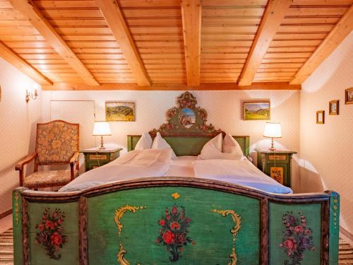 a green bed in a room with two tables and two lamps at Hochkönig in Kirchberg in Tirol