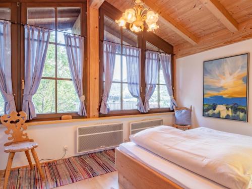 a bedroom with a large bed and windows at Hochkönig in Kirchberg in Tirol