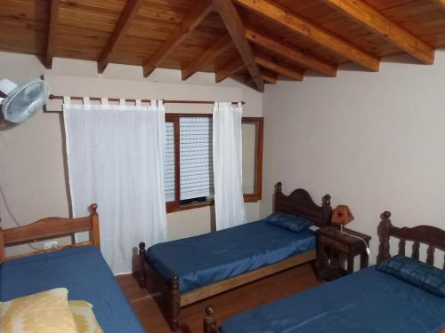 a bedroom with two beds and a window at Modernos departamentos PB cerca del centro y del mar in Mar de Ajó