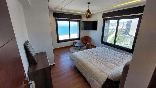 een slaapkamer met een bed en 2 grote ramen bij Tanger Luxury Family Appartments, Boulevard. in Tanger