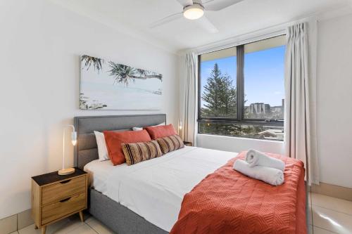ein Schlafzimmer mit einem Bett und einem großen Fenster in der Unterkunft Seascape - Hosted by Burleigh Letting in Gold Coast