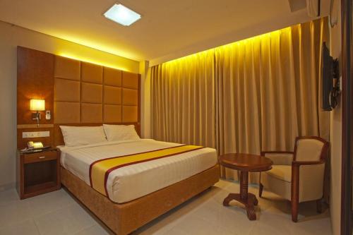 um quarto com uma cama, uma mesa e uma cadeira em Hotel Grand Rahmania, Central Motijheel-Dhaka em Daca