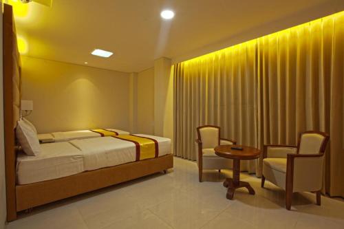 a bedroom with a bed and a table and chairs at Hotel Grand Rahmania, Central Motijheel-Dhaka in Dhaka