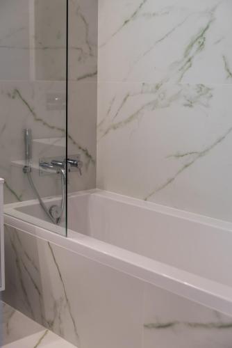 a white bathroom with a shower with a glass wall at Lux 56 Praia da Barra Aveiro A 20 metros da Praia in Praia da Barra