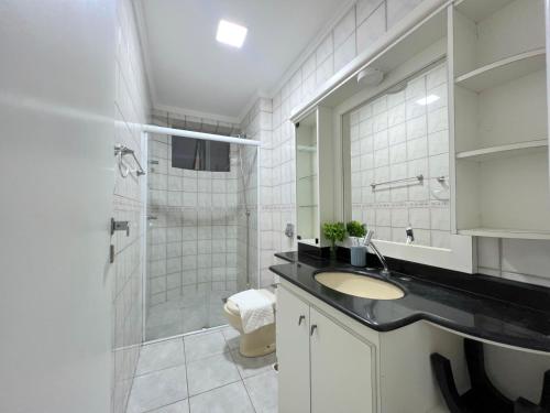 a white bathroom with a sink and a shower at Apartamento 3 quartos e boas energias in Balneário Camboriú