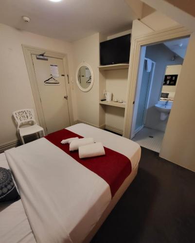 a bedroom with a bed with two towels on it at The Shakespeare Hotel in Auckland