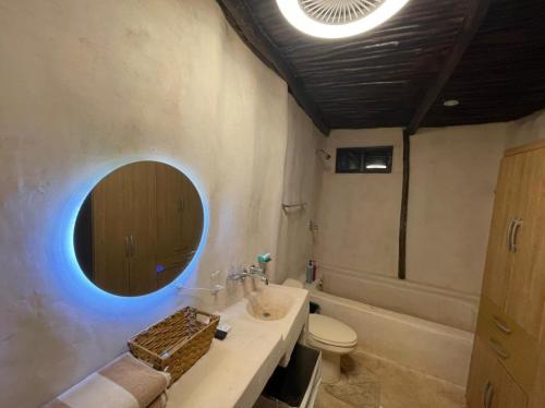 a bathroom with a sink and a toilet and a mirror at Cabañas Casvar in Balcheil