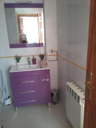 La salle de bains est pourvue d'un lavabo violet et d'un miroir. dans l'établissement CALIDAS HABITACIONES DOBLES, BAÑO PRIVADO y PATIO, à Villalbilla