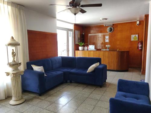 a living room with a blue couch and two chairs at La Posada Norteña in Lambayeque