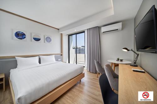 a hotel room with a bed and a tv at Prom Hotel in Bangkok