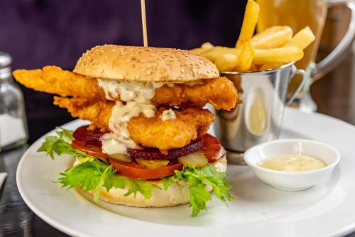 a chicken sandwich and french fries on a plate at The Shakespeare Hotel in Auckland