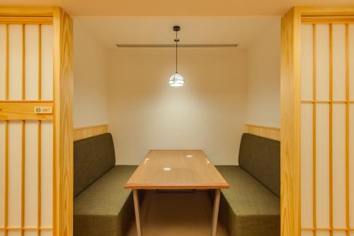 a dining room with a table and benches at UreshinoOnsen URESHINO YADOYA in Ureshino