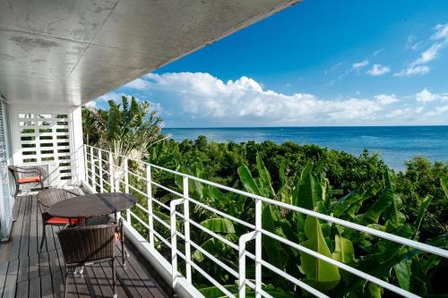 a balcony with a table and chairs and the ocean at NEWOPEN　オーシャンビューの一軒家 in Ishigaki Island