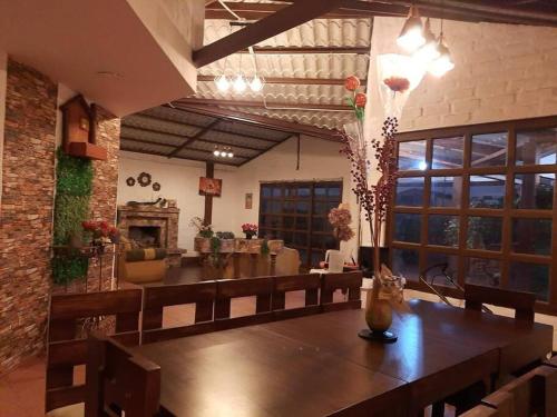 a dining room with a table and a living room at Casa de campo con hermosa vista in Riobamba