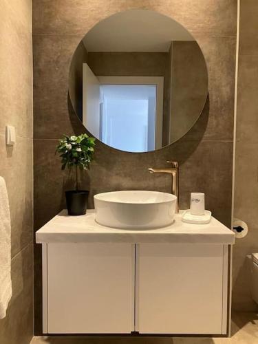 a bathroom with a sink and a mirror at Vila Lana - Heated pool - Sea view - Two independent floors in Faro