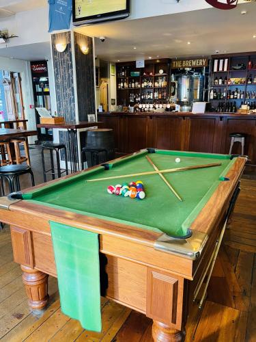 a pool table in the middle of a bar at The Shakespeare Hotel in Auckland