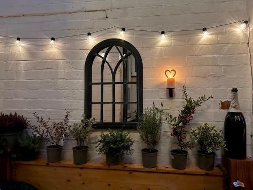 ein Zimmer mit Topfpflanzen auf einem Tisch und einem Spiegel in der Unterkunft The Bolt Hole in Stratford-upon-Avon