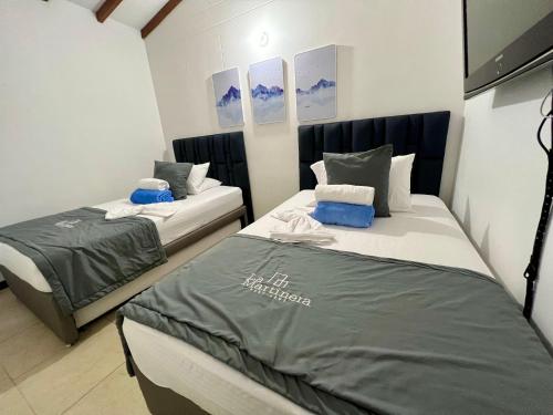 a bedroom with two beds in a room at Hermoso Apartasol!! cerca a Plaza Principal, Aire Acondicionado, Vista a la Piscina in Santa Fe de Antioquia
