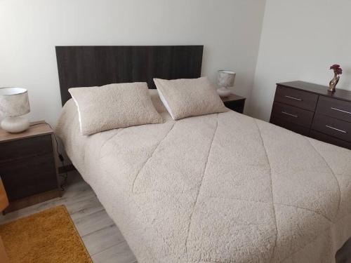 a bedroom with a large bed with two pillows at Departamento nuevo en reñaca alto 2 dormitorios in Viña del Mar