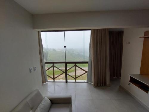 a living room with a large window with a view at Apartamento sonhos da serra bananeiras in Bananeiras