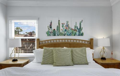 um quarto com uma cama com lençóis brancos e 2 candeeiros em Casa Rosa - A Ryson Property em Palm Springs
