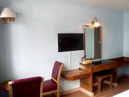a hotel room with a desk and a mirror at ปิดชั่วคราว ชิดลม in Makkasan
