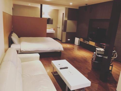 um quarto de hotel com duas camas e um sofá em LUXe em Higashihiroshima