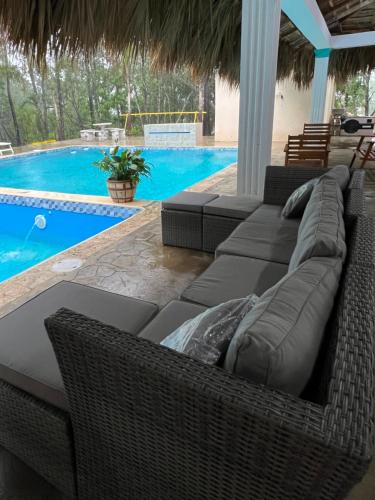 a patio with wicker furniture and a swimming pool at Hermosa villa Renacer in Concepción de La Vega