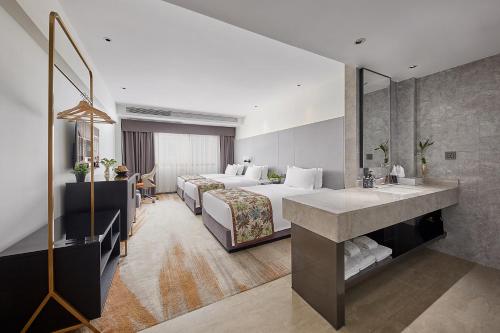a hotel room with two beds and a sink at Dashen Hotel Shunde Lecong in Shunde