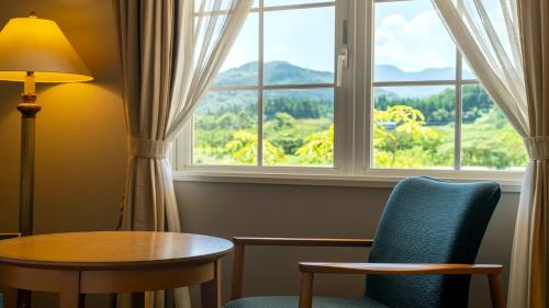 a room with a table and chairs and a window at Satoyama Auberge & Hot Spring Wellness Spa Sakuragaike Kurgarden in Nanto