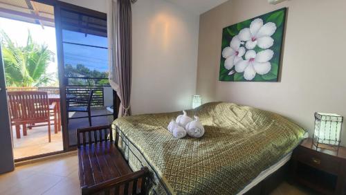 a bedroom with a bed with a stuffed animal on it at Oasis Garden & Pool Villa at VIP Resort in Ban Phe