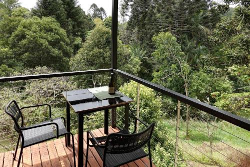 a balcony with two chairs and a table on a deck at Kaalba in Maleny