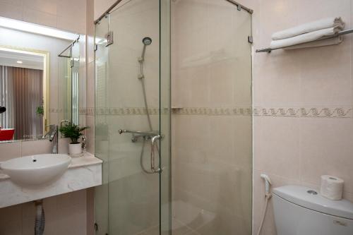 a bathroom with a shower and a toilet and a sink at Quy Hung Hotel Central in Ho Chi Minh City