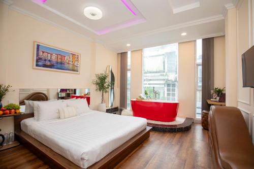 a bedroom with a large white bed and a red tub at Quy Hung Hotel Central in Ho Chi Minh City