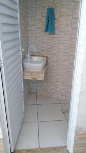 Baño pequeño con lavabo y toalla en pousada&Hostel perola mar, en Mongaguá