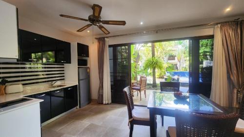 a kitchen with a ceiling fan and a table with chairs at Oasis Garden & Pool Villa at VIP Resort in Ban Phe