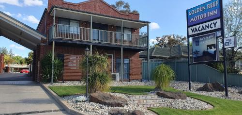 ein Haus mit einem Schild davor in der Unterkunft Golden Reef Motor Inn in Bendigo