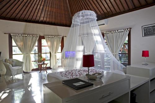 a bedroom with a bed with a veil on it at Natah Bale Villas in Sanur
