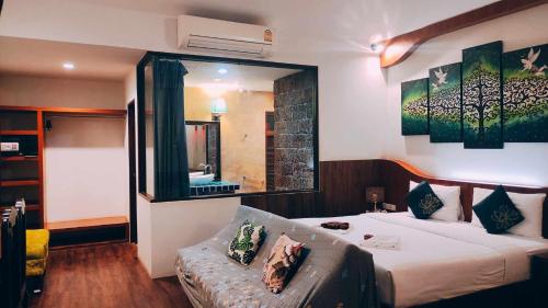 a bedroom with a bed and a large mirror at Foresto Sukhothai Guesthome in Sukhothai