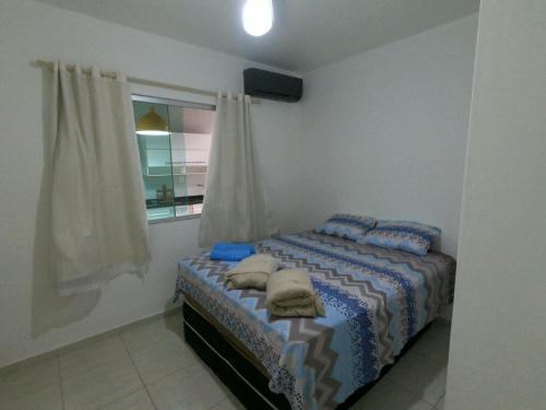 a bedroom with a bed with pillows and a window at Luxo nas Ondas: Casa de Praia de Alto Padrão in São João da Barra