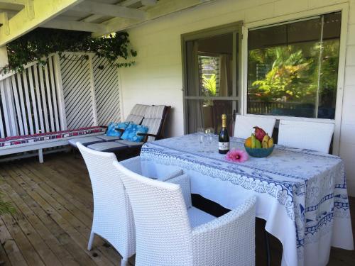 a table with a bowl of fruit on a patio at Herons Reef Holiday Apartments in Rarotonga