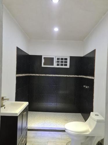 a bathroom with a white toilet and a sink at Departamento villas in La Cantera