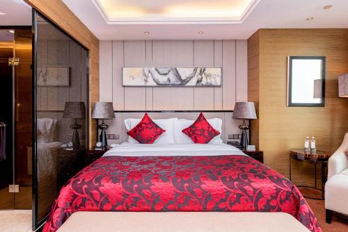 a bedroom with a large red bed with red pillows at Shenzhen LANGYUE International Hotel in Longgang
