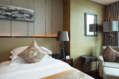 a hotel room with a bed and a chair at Shenzhen LANGYUE International Hotel in Longgang