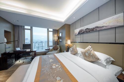 a hotel room with a large bed and a desk at Shenzhen LANGYUE International Hotel in Longgang