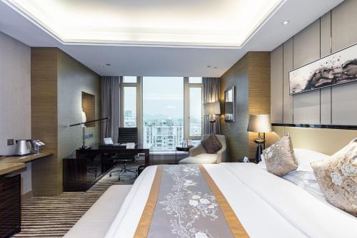 a hotel room with a large bed and a desk at Shenzhen LANGYUE International Hotel in Longgang