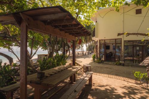 a wooden bench in front of a building at Thundi Village & Spa in Maalhos
