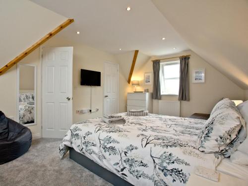 a bedroom with a large bed and a television at Coastal Gem in Weymouth