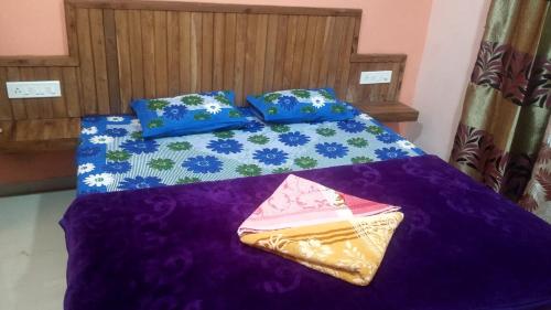 サーターラーにあるNamasvi villa Mahabaleshwarのベッド1台(紫の毛布、枕2つ付)